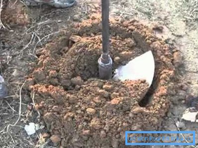 На фотографијата - дупчење бунар за вода во една приградска област со домашна алатка На фотографијата - дупчење бунар за вода во една приградска област со домашна алатка